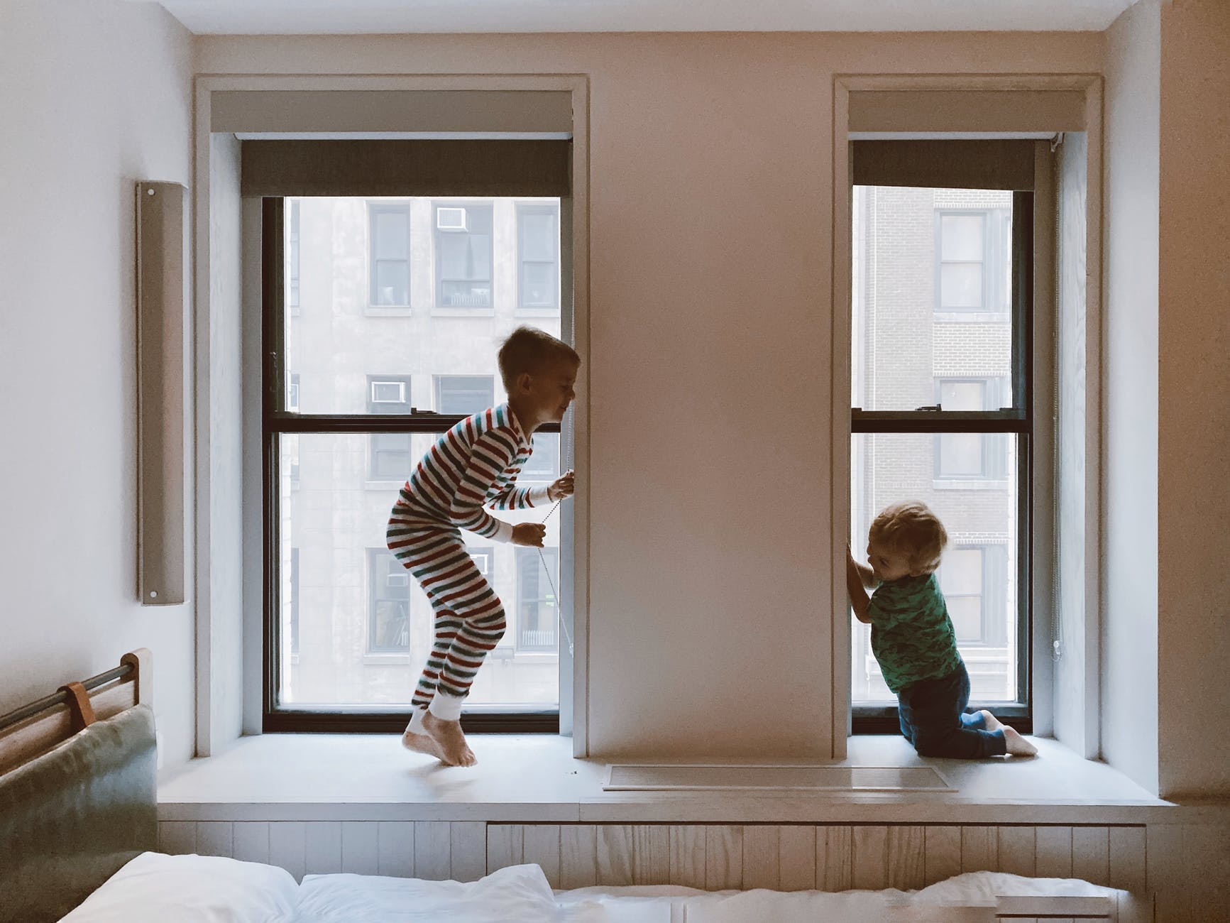 two kids playing beside glass windows